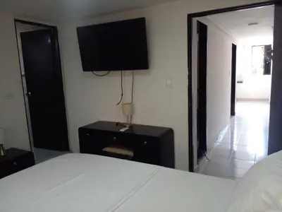 a bedroom with a bed and a television on the wall at Ideal house for Carnival in Barranquilla