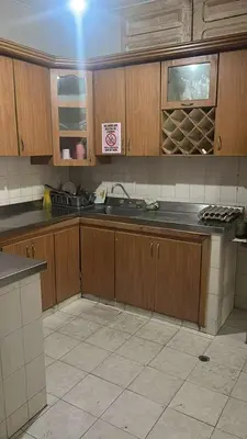 a kitchen with wooden cabinets and a sink at Habitacion con baño en zona de carnaval in Barranquilla