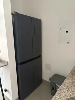 a black refrigerator in the corner of a room at Cardona Suite Santa Marina Santa Marta in Santa Marta