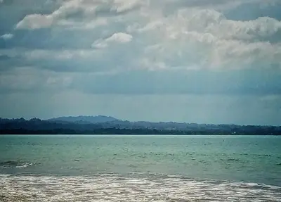 a large body of water under a cloudy sky at El Castillo in Moñitos