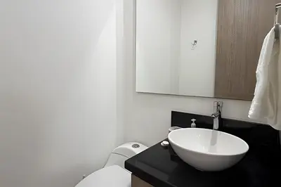 a bathroom with a white bowl sink on a black counter at Hermoso Apto de 1 hab con Vista al Mar - Piso 10 in Cartagena de Indias