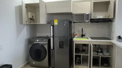 a kitchen with a refrigerator and a washing machine at Apartamento Lujoso en Cartagena a pocos pasos del Aeropuerto in Cartagena de Indias