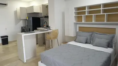 a bedroom with a bed and a desk and a kitchen at Apartamento Lujoso en Cartagena a pocos pasos del Aeropuerto in Cartagena de Indias