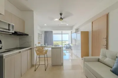 a kitchen and living room with a couch and a table at Apartamento Lujoso en Cartagena a pocos pasos del Aeropuerto in Cartagena de Indias