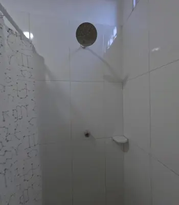 a bathroom with a shower with a white tile wall at Hostel Casa Kanaloa Isla de Baru in Ararca