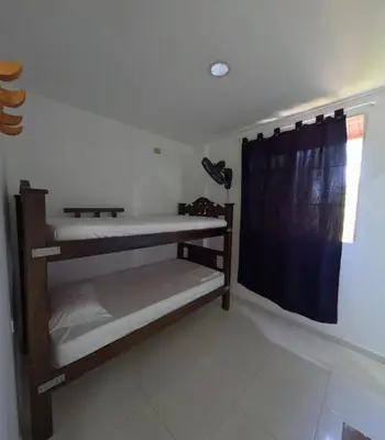 a room with two bunk beds and a window at Hostel Casa Kanaloa Isla de Baru in Ararca