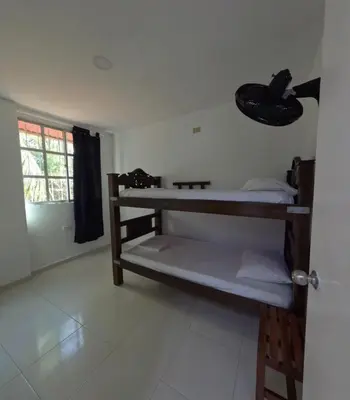 a room with two bunk beds and a window at Hostel Casa Kanaloa Isla de Baru in Ararca
