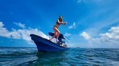 a woman in a bikini on a boat in the ocean at Hostel Casa Kanaloa Isla de Baru in Ararca