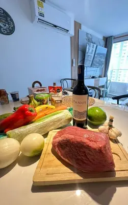 a steak on a cutting board next to a bottle of wine at Caribbean Deluxe Apartment Walk to Beach WiFi in Cartagena de Indias
