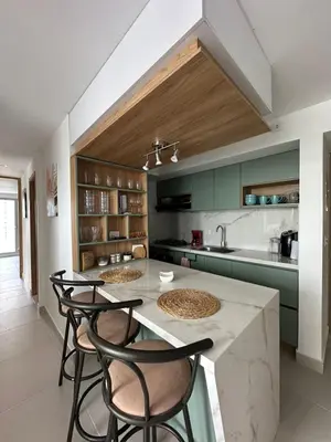 a kitchen with green cabinets and a table with chairs at Caribbean Deluxe Apartment Walk to Beach WiFi in Cartagena de Indias