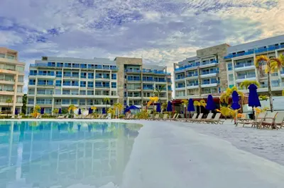 a swimming pool with chairs and umbrellas in front of buildings at 1 Recamara, Laguna, Paddleboard, Gym y Jacuzzi in Cartagena de Indias