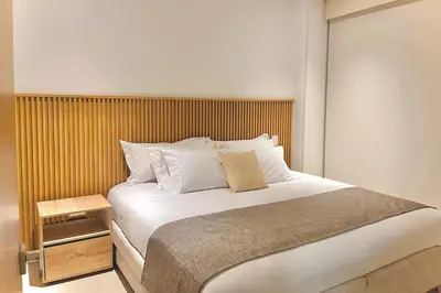 a bedroom with a large bed with a wooden headboard at 1 Recamara, Laguna, Paddleboard, Gym y Jacuzzi in Cartagena de Indias