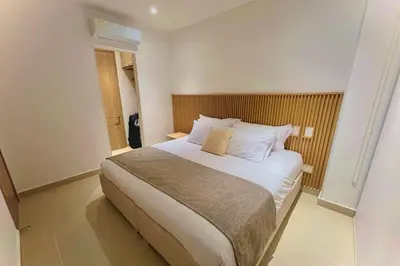 a bedroom with a large bed with white sheets and pillows at 1 Recamara, Laguna, Paddleboard, Gym y Jacuzzi in Cartagena de Indias