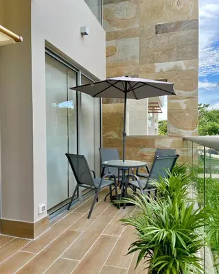 a patio with a table and chairs and an umbrella at 1 Recamara, Laguna, Paddleboard, Gym y Jacuzzi in Cartagena de Indias