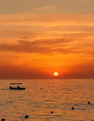 a boat in the ocean at sunset at Modern Balcony Apartment with Sea View! in Santa Marta