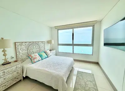 a bedroom with a bed and a large window at 3br Apartment in front of the beach 8 paxs in Cartagena de Indias