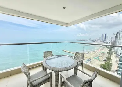 a balcony with a table and chairs and the ocean at 3br Apartment in front of the beach 8 paxs in Cartagena de Indias