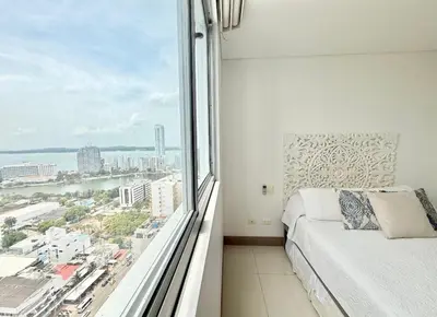 a bedroom with a bed and a large window at 3br Apartment in front of the beach 8 paxs in Cartagena de Indias