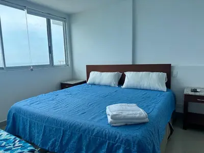 a bedroom with a blue bed with two towels on it at 2BR apartment Ocean & old city view in Cartagena de Indias