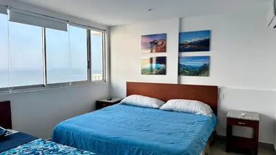 a bedroom with two beds and pictures on the wall at 2BR apartment Ocean & old city view in Cartagena de Indias