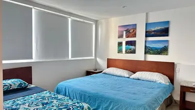 a bedroom with two beds and pictures on the wall at 2BR apartment Ocean & old city view in Cartagena de Indias