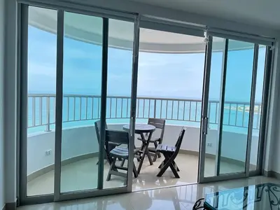 a dining room with a table and chairs on a balcony at 2BR apartment Ocean & old city view in Cartagena de Indias