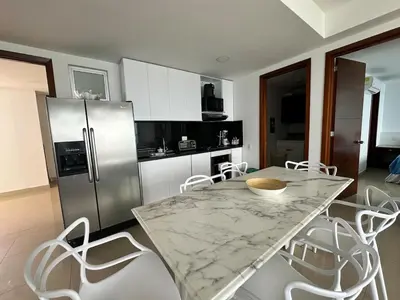 a kitchen with a marble table and white chairs at 2BR apartment Ocean & old city view in Cartagena de Indias