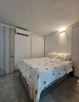 a bedroom with a bed with a white comforter at Apartamento completo, serena del mar, Capriella in Cartagena de Indias