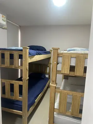 two wooden bunk beds in a room with blue sheets at Apartment in Barranquilla in Barranquilla