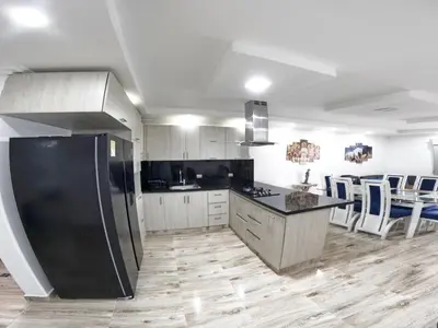 a kitchen with a black refrigerator and white cabinets at Apartamento Mirador cerca al Centro Historico in Cartagena de Indias