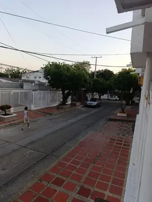 a young girl walking down a street with a car at Salomón el rey in Barranquilla