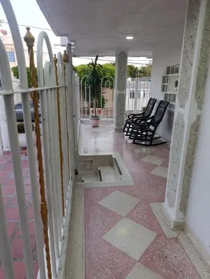 a porch with black chairs and a porch at Salomón el rey in Barranquilla
