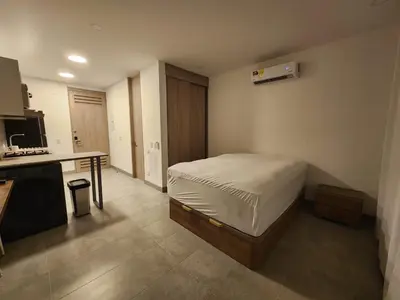 a bedroom with a bed and a desk in it at Apartamento vacacional con acceso al mar in Santa Marta