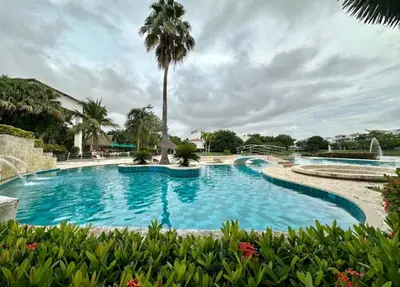 a large swimming pool with a palm tree in the background at CONDOMINIO LAGUNA CLUB 