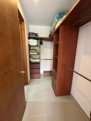 a walk in closet with wooden cabinets and a door at CONDOMINIO LAGUNA CLUB 