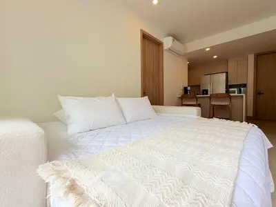 a large white bed in a room with a kitchen at 2-Bedroom Apartment with Private Pool - Morros Kai in Cartagena de Indias