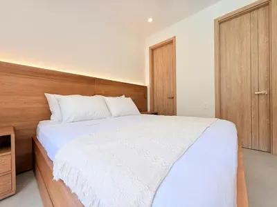 a bedroom with a large white bed with a wooden headboard at 2-Bedroom Apartment with Private Pool - Morros Kai in Cartagena de Indias
