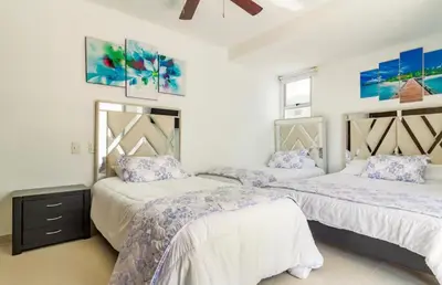 two beds in a bedroom with purple and white at Espectacular Apartamento salida directa a playa in Cartagena de Indias