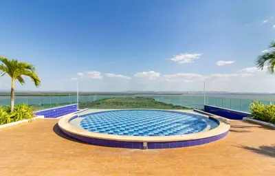 a large swimming pool with a view of the ocean at Espectacular Apartamento salida directa a playa in Cartagena de Indias