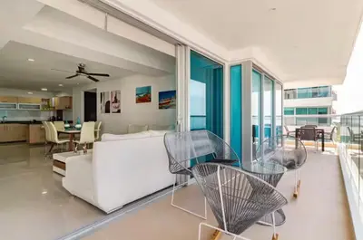 a living room with a white couch and chairs at Espectacular Apartamento salida directa a playa in Cartagena de Indias