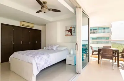a bedroom with a bed and a table and chairs at Espectacular Apartamento salida directa a playa in Cartagena de Indias