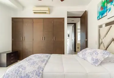 a bedroom with a large bed and wooden cabinets at Espectacular Apartamento salida directa a playa in Cartagena de Indias