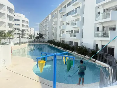 a man playing in a pool in front of a building at Serena del Mar in Cartagena de Indias
