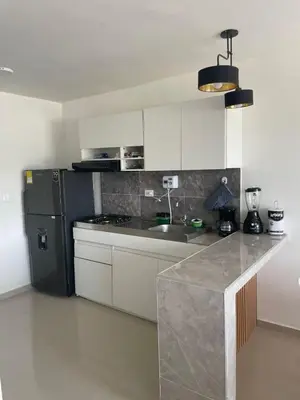 a kitchen with a counter and a black refrigerator at Modern & Cozy Apartment Near the Beach in Cartagena de Indias