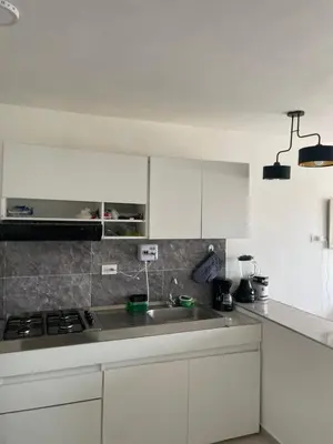 a kitchen with white cabinets and a sink at Modern & Cozy Apartment Near the Beach in Cartagena de Indias
