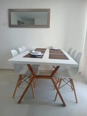 a dining room table with white chairs and a mirror at Modern & Cozy Apartment Near the Beach in Cartagena de Indias
