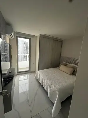 a white bedroom with a bed and a window at Apt 2605 in Cartagena de Indias