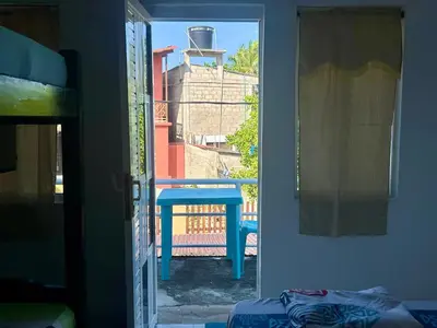 a room with a door to a balcony with a table at Costa Azul Isla Fuerte in Isla Fuerte