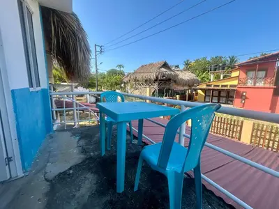 a blue table and two chairs on a balcony at Costa Azul Isla Fuerte in Isla Fuerte