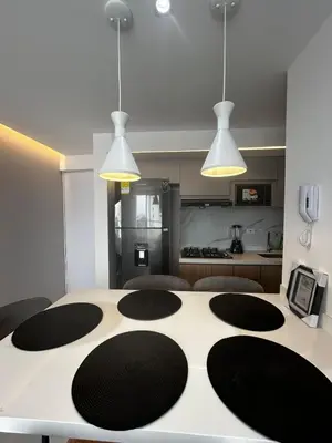 a kitchen with a white table with three lights at Apt 2704 in Cartagena de Indias